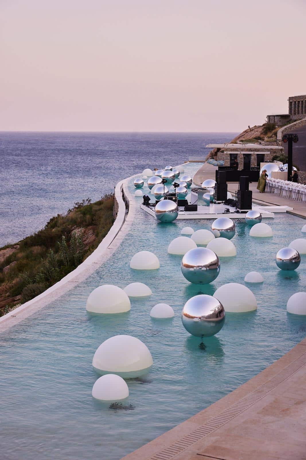 Chrome LED orbs reflecting in infinity pool at night in Mykonos