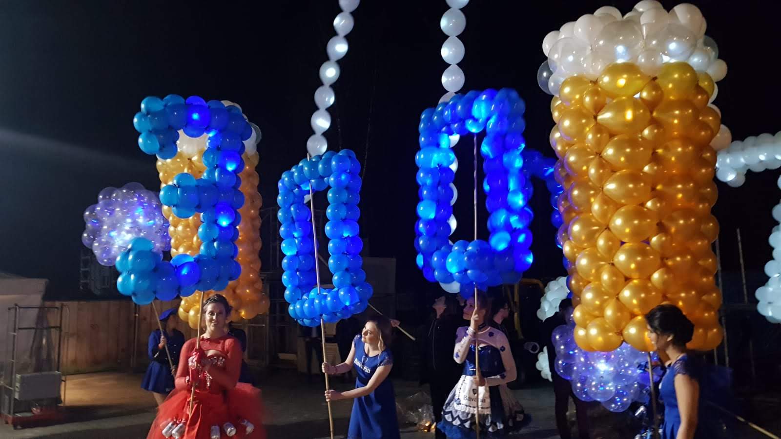 Performers with large balloon beer glasses during the Bavaria 300 Jaar brand activation in Lieshout (2019)