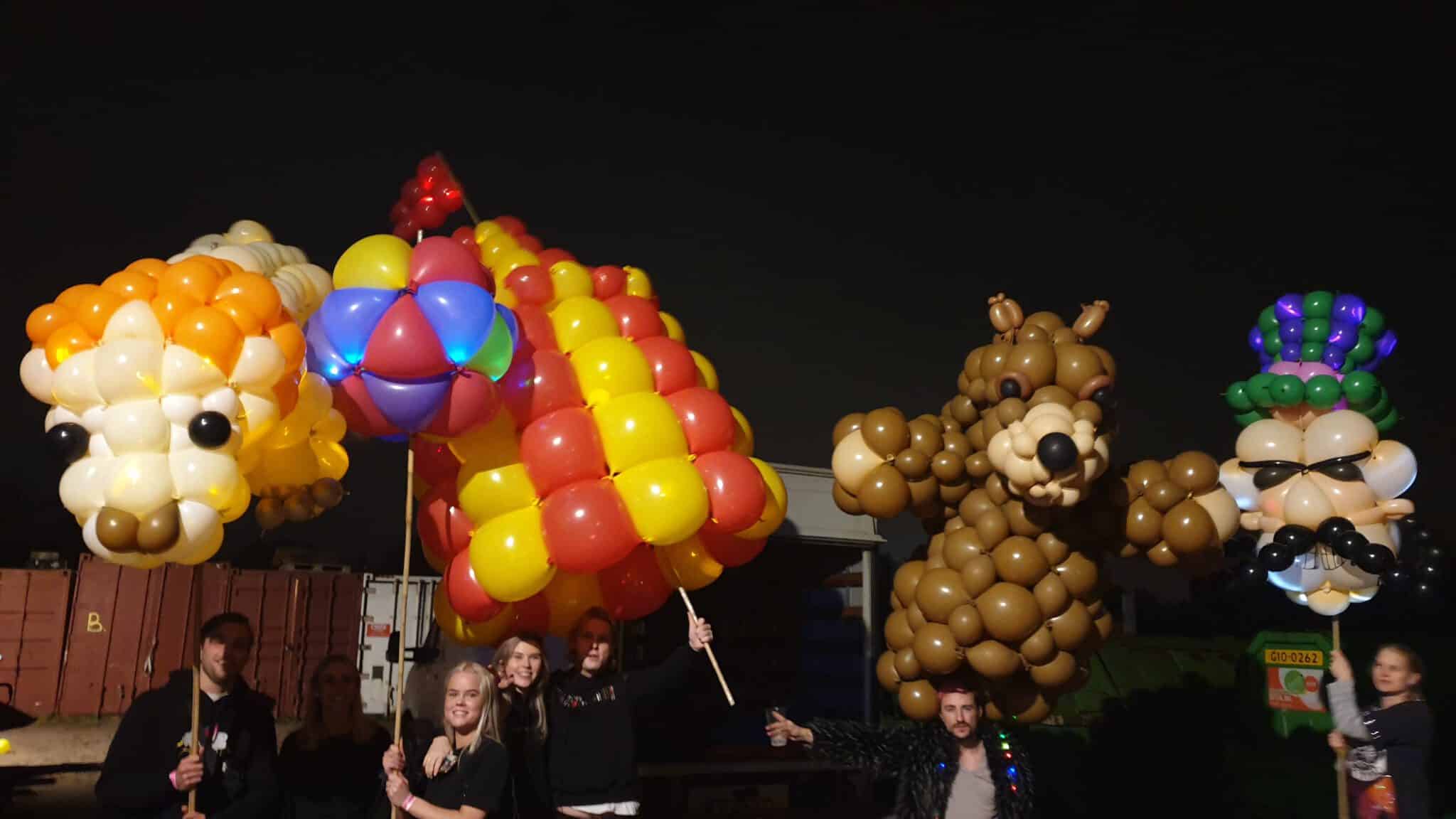 Balloon animal parade sculptures featuring lion, sailboat, and bear characters at night (2019) — Float of Thin Air